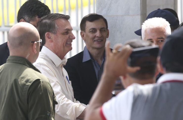 O Presidente Jair Bolsonaro cumprimenta  populares ao sair do Palácio da Alvorada