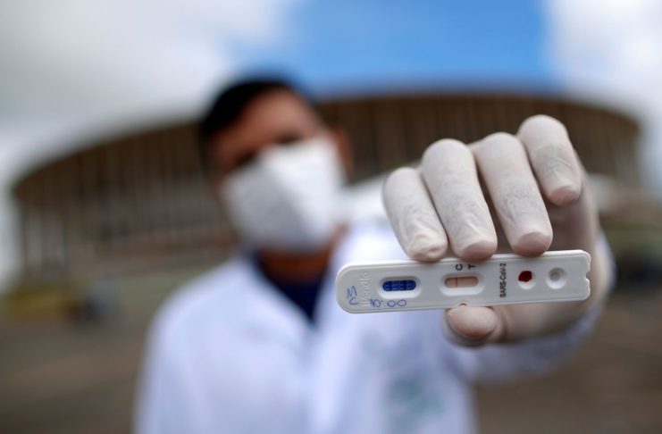 Um profissional médico mostra um teste negativo para o novo coronavírus em frente ao Estádio Mane Garrincha, em meio ao surto da doença por coronavírus (COVID-19), em Brasília, Brasil, 21 de abril de 2020. REUTERS / Ueslei Marcelino