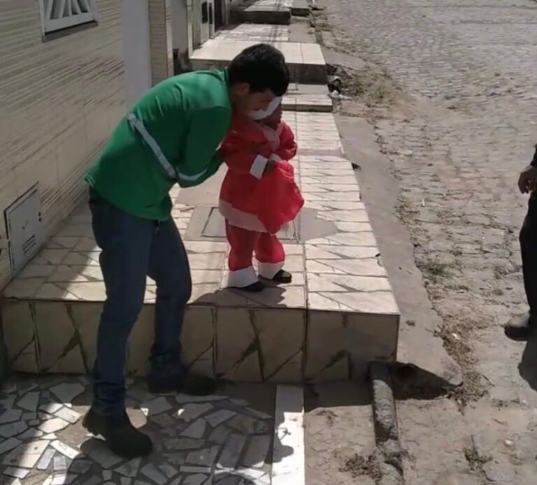 Vestido de Papai Noel, criança distribui panetones para os garis de Lagarto