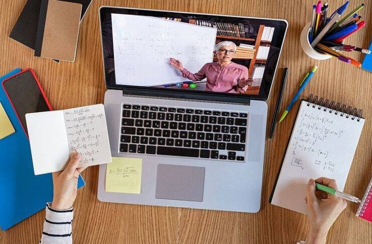 High angle view of video conference with teacher on laptop at home. Top view of girl in video call with personal tutor on computer listening audio course, distance and e-learning education concept. (High angle view of video conference with teacher on