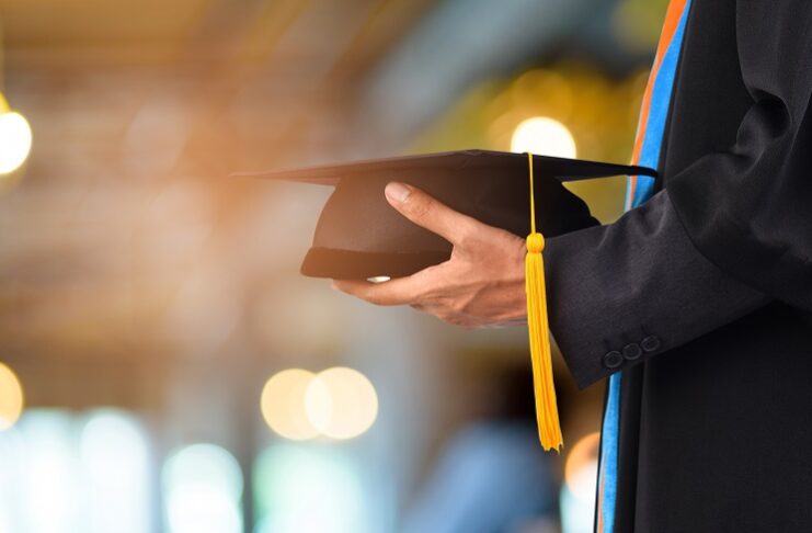 Graduation take a black yellow tassel in front of bokeh blurry background.