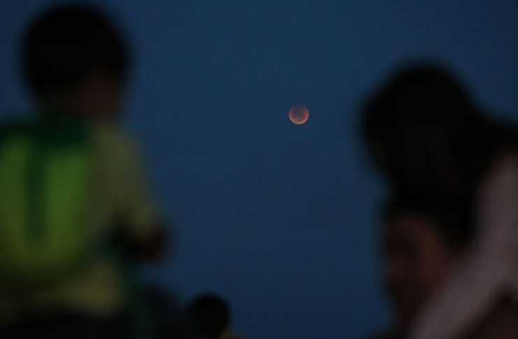 Crianças observam o eclipse total da lua, em que o astro ganha tons avermelhados, conhecido como Lua de Sangue, no Forte de Copacabana.